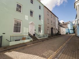 A street with colorful buildings and a cloudy sky at Flat 4 Tenby