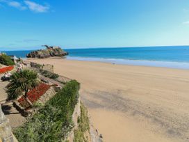 A beach with palm trees and flowers along the path at Flat 4 Tenby