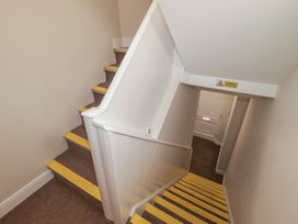 A staircase with yellow steps and a caution sign at Flat 1 in Tenby