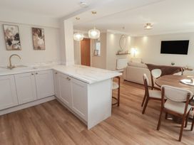 A kitchen and dining area with cabinets and furniture at Flat 1 in Tenby