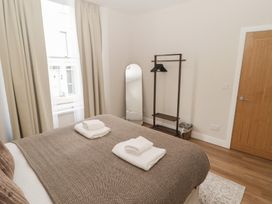 A bedroom with a bed and towels on top at Flat 1 in Tenby