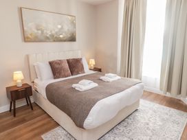 A bedroom with a bed and nightstand at Flat 1 in Tenby