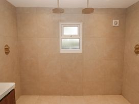 A bathroom with shower facilities and a window at Flat 1 in Tenby