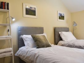 A bedroom with two beds and shelves at The Hayloft in Hexham