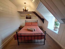 A bedroom with a bed, shelves, and a window at Y Cwtch in Dolgellau