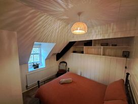 A bedroom with a bed and chair at Y Cwtch in Dolgellau