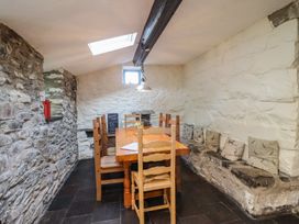 A dining room with a wooden table and chairs at Y Cwtch Dolgellau