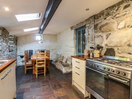A kitchen with a dining table and chairs at Y Cwtch in Dolgellau
