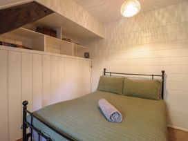 A bedroom with a bed and a bookshelf at Y Cwtch in Dolgellau