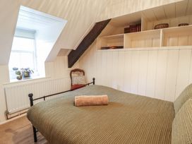 A bedroom with a bed and window at Y Cwtch in Dolgellau