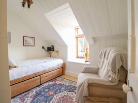 A bedroom with a bed, armchair and window at Waen Fechan in Dolgellau