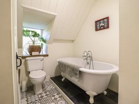 A bathroom with a bathtub, toilet, and a window at Waen Fechan in Dolgellau