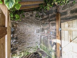 An outdoor shower area with stone walls and a wooden door at Waen Fechan in Dolgellau