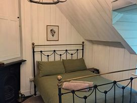 A bedroom with a bed and a painting at Waen Fechan in Dolgellau