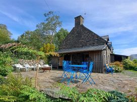 A stone house with a patio, table and chairs at Waen Fechan in Dolgellau