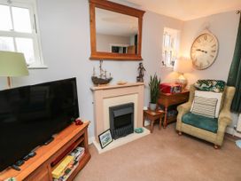 A living room with a television, fireplace, and armchair at 1 St. Anns Lane, Whitby