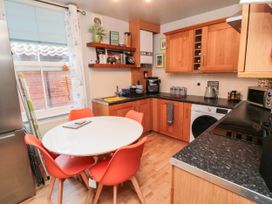 A kitchen with a round table and red chairs at 1 St. Anns Lane in Whitby
