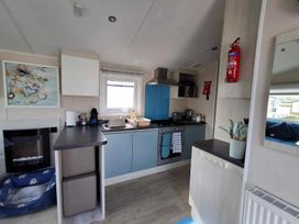 A kitchen with sink and stove at Lyons Sunnysands - Snowdon Summit 050 Talybont