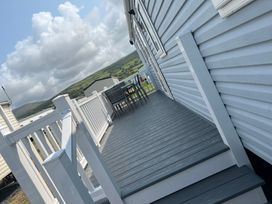 An outdoor deck with a table and chairs at Lyons Sunnysands - Snowdon Summit 050 Talybont