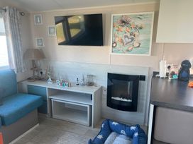 A living room with a television and fireplace at Lyons Sunnysands - Snowdon Summit 050, Talybont