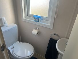 A bathroom with a toilet and a sink at Lyons Sunnysands - Snowdon Summit 050 Talybont