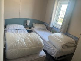 A bedroom with two single beds at Lyons Sunnysands - Snowdon Summit 050 Talybont