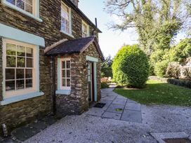 An outdoor view of a stone wall and pathway at Jessicas Cottage in Windermere
