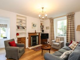 A living room with a fireplace and bookshelf at Jessicas Cottage in Windermere
