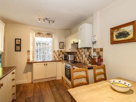 A kitchen with cabinets and appliances at Jessicas Cottage in Windermere