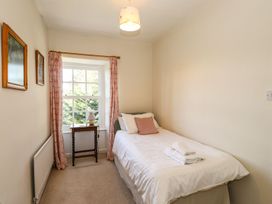 A bedroom with a bed and bedside table at Jessicas Cottage in Windermere
