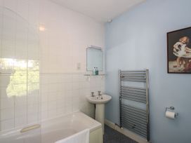 A bathroom with a bathtub, sink and towel radiator at Jessicas Cottage in Windermere
