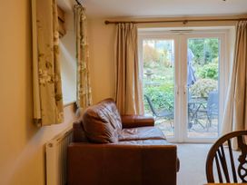 A living room with a sofa and a view of the garden at Coombe Cottage Apartment Axmouth