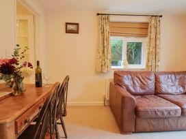 A living room with a table and sofa at Coombe Cottage Apartment in Axmouth