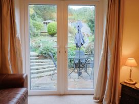 A living room with double doors opening to a garden at Coombe Cottage Apartment Axmouth
