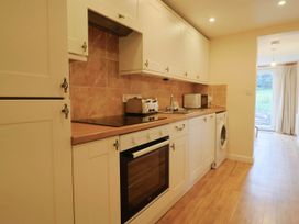 A kitchen with appliances and cabinets at Coombe Cottage Apartment in Axmouth