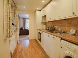A kitchen with appliances and a window at Coombe Cottage Apartment in Axmouth