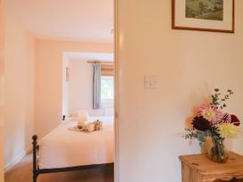 A bedroom with a bed and table at Coombe Cottage Apartment Axmouth