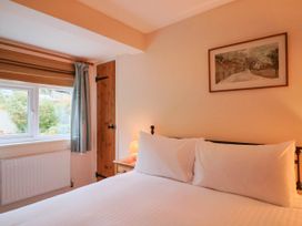 A bedroom with a bed and window at Coombe Cottage Apartment in Axmouth