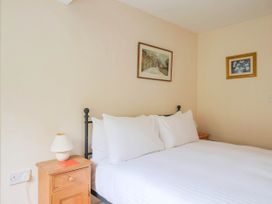 A bedroom with a bed and bedside table at Coombe Cottage Apartment in Axmouth