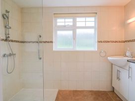 A bathroom with a shower and wash basin at Coombe Cottage Apartment Axmouth