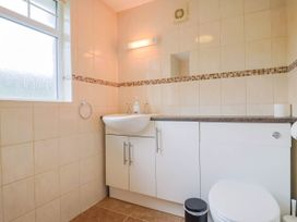 A bathroom with a sink, toilet, and window at Coombe Cottage Apartment Axmouth