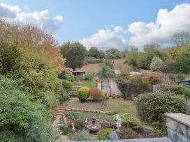 A garden with a fountain and greenery at Coombe Cottage Apartment in Axmouth