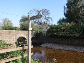 A bridge and signpost near a river at Coombe Cottage Apartment Axmouth