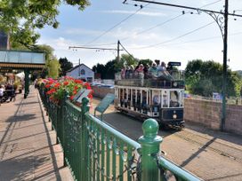 An outdoor scene with a tram and flowers at Coombe Cottage Apartment Axmouth