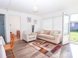 A living room with a sofa, armchair and rug at 122 Norton Park, Dartmouth