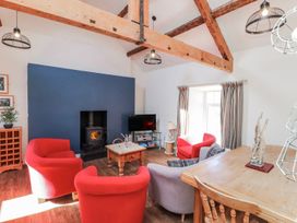 A living room with a sofa, chairs, and a fireplace at Hen Blas in Pwllheli