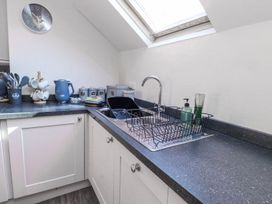 A kitchen with a sink and dish rack at Hen Blas Pwllheli