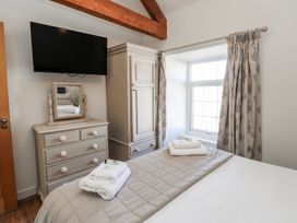A bedroom with a bed and television at Hen Blas in Pwllheli
