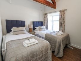 A bedroom with two beds and a window at Hen Blas in Pwllheli
