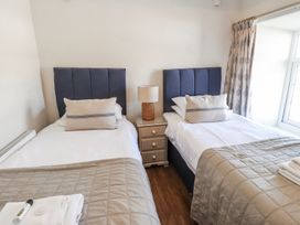 A bedroom with twin beds and a nightstand at Hen Blas in Pwllheli